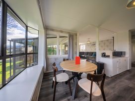 A dining area with a round table and chairs at Quiet on Quintin - Te Anau Holiday Home, Te Anau