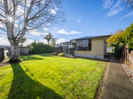 A garden with grass and trees at Quiet on Quintin - Te Anau Holiday Home Te Anau