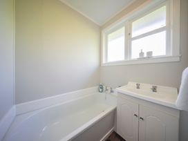 A bathroom with a bathtub and sink at Quiet on Quintin - Te Anau Holiday Home Te Anau