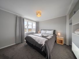 A bedroom with a bed and window at Quiet on Quintin - Te Anau Holiday Home Te Anau