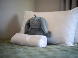 A stuffed animal and a towel on a bed at Quiet on Quintin - Te Anau Holiday Home Te Anau
