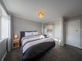 A bedroom with a bed and bedside table at Quiet on Quintin - Te Anau Holiday Home, Te Anau