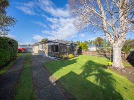 An outdoor area featuring a house, yard, and tree at Quiet on Quintin - Te Anau Holiday Home, Te Anau
