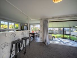 A dining room with a table and chairs at Quiet on Quintin - Te Anau Holiday Home in Te Anau