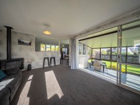 A living room with a sofa and fireplace at Quiet on Quintin - Te Anau Holiday Home in Te Anau