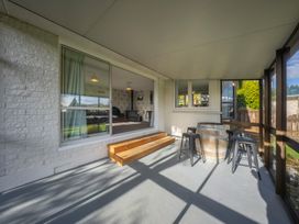 An outdoor area with wooden steps and seating at Quiet on Quintin - Te Anau Holiday Home Te Anau