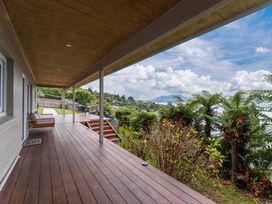 A deck area with seating and steps at Serenity Above the Lake - Acacia Bay