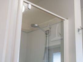 A shower with a shower head and hanger at Serenity Above the Lake - Acacia Bay Holiday Home Acacia Bay