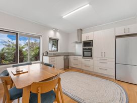 A kitchen with a dining table and appliances at Serenity Above the Lake - Acacia Bay