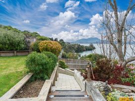 A garden with stairs leading down to a lake at Serenity Above the Lake - Acacia Bay Holiday Home, Acacia Bay