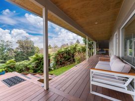 A porch with a couch and plants at Serenity Above the Lake - Acacia Bay