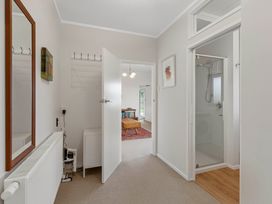 A hallway with a mirror and coat hooks at Serenity Above the Lake - Acacia Bay