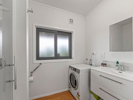 A laundry room with a washing machine and sink at Serenity Above the Lake - Acacia Bay