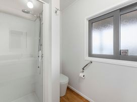 A bathroom with a shower and toilet at Serenity Above the Lake - Acacia Bay