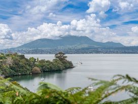 A view of a lake with trees and mountains at Serenity Above the Lake - Acacia Bay