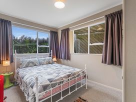 A bedroom with a bed and curtains at JOE'S Getaway - Omori Holiday Home Omori