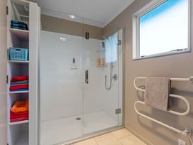 A shower with towels and storage in a bathroom at JOE'S Getaway - Omori Holiday Home Omori