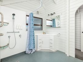 A bathroom with a shower and sink at Hawkings Lodge - Kerikeri Holiday home