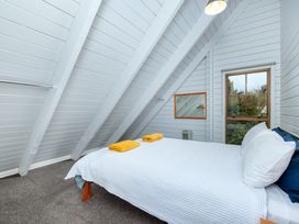 A bedroom with a bed and towels on it at Hawkings Lodge - Kerikeri Holiday home