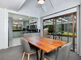 A dining room with a wooden table and chairs at Hawkings Lodge - Kerikeri Holiday home