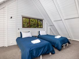 A bedroom with two beds and a window at Hawkings Lodge - Kerikeri Holiday home