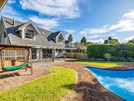 An outdoor area with a house, swing, pool, and lawn at Hawkings Lodge - Kerikeri Holiday home