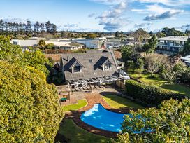 An outdoor area with a house and swimming pool at Hawkings Lodge - Kerikeri Holiday home