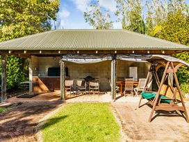 An outdoor area with a swing and seating at Hawkings Lodge - Kerikeri Holiday home