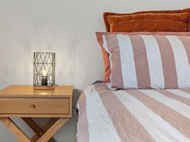 A bedroom with a bedside table and lamp at Wanaka Holiday Home in Wanaka