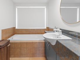 A bathroom with a bathtub and sink at Wanaka Holiday Home in Wanaka