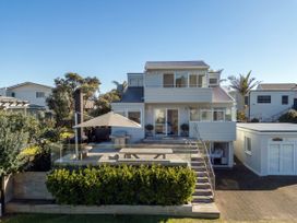 A house with a deck and outdoor furniture at Whangamata Holiday Home in Whangamata