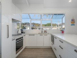 A kitchen with a sink and cabinets at Whangamata Holiday Home in Whangamata