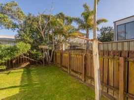 An outdoor area with trees and a fence at Whangamata Holiday Home in Whangamata