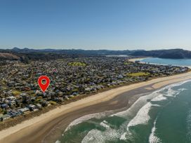 An aerial view of a beach and houses at Whangamata Holiday Home in Whangamata