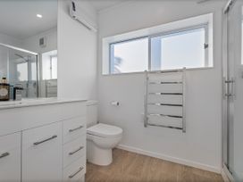 A bathroom with a sink and toilet at Whangamata Holiday Home in Whangamata