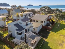 A view of several houses near the ocean at Whangamata Holiday Home in Whangamata