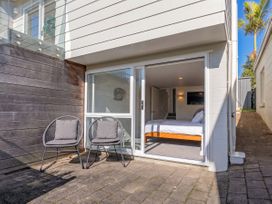 A bedroom with a bed and sliding door at Whangamata Holiday Home in Whangamata