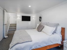 A bedroom with a bed and TV at Whangamata Holiday Home in Whangamata