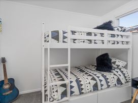 A bunk bed with a guitar in a bedroom at Whangamata Holiday Home in Whangamata