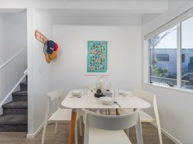 A dining room with a table and chairs at Whangamata Holiday Home in Whangamata