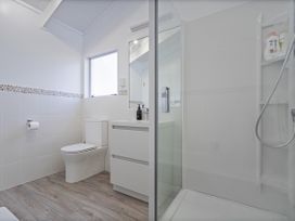 A bathroom with a shower, sink, and toilet at Whangamata Holiday Home in Whangamata