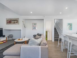 A living room with a sofa and coffee table at Whangamata Holiday Home in Whangamata