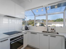 A kitchen with a stovetop, sink and kitchen appliances at Whangamata Holiday Home in Whangamata
