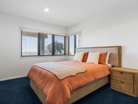A bedroom with a bed and nightstand at Sunbrae Sands - Mount Maunganui Holiday Homes