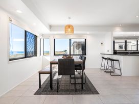 A dining room with a table and chairs at Sunbrae Sands - Mount Maunganui