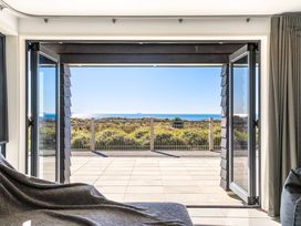 An indoor view with a door opening to an ocean landscape at Sunbrae Sands - Mount Maunganui Holiday Homes, Mount Maunganui