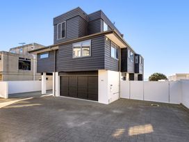 A house with a garage and paved driveway at Sunbrae Sands - Mount Maunganui Holiday Homes Mount Maunganui