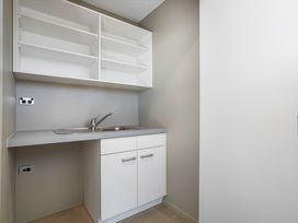 A laundry room with a sink and cabinets at Sunbrae Sands - Mount Maunganui Holiday Homes