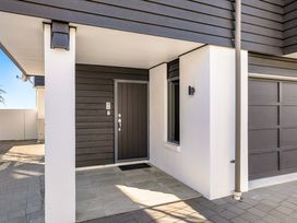 An entrance with a front door and garage door at Sunbrae Sands - Mount Maunganui