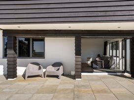 An outdoor area with chairs and a view at Sunbrae Sands - Mount Maunganui Holiday Homes